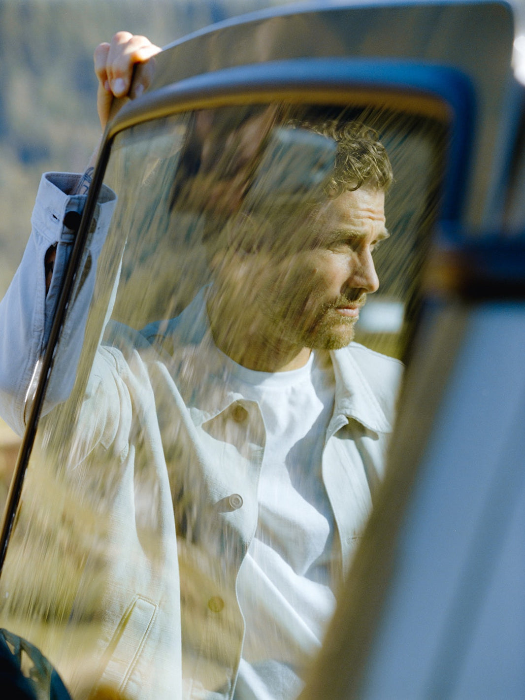A man looking thoughtful through a car window, reflecting on life and relationships.